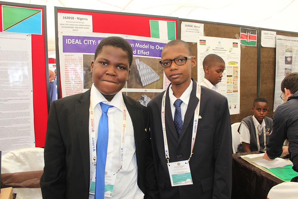 Two students at their Ideal City urban model project stand