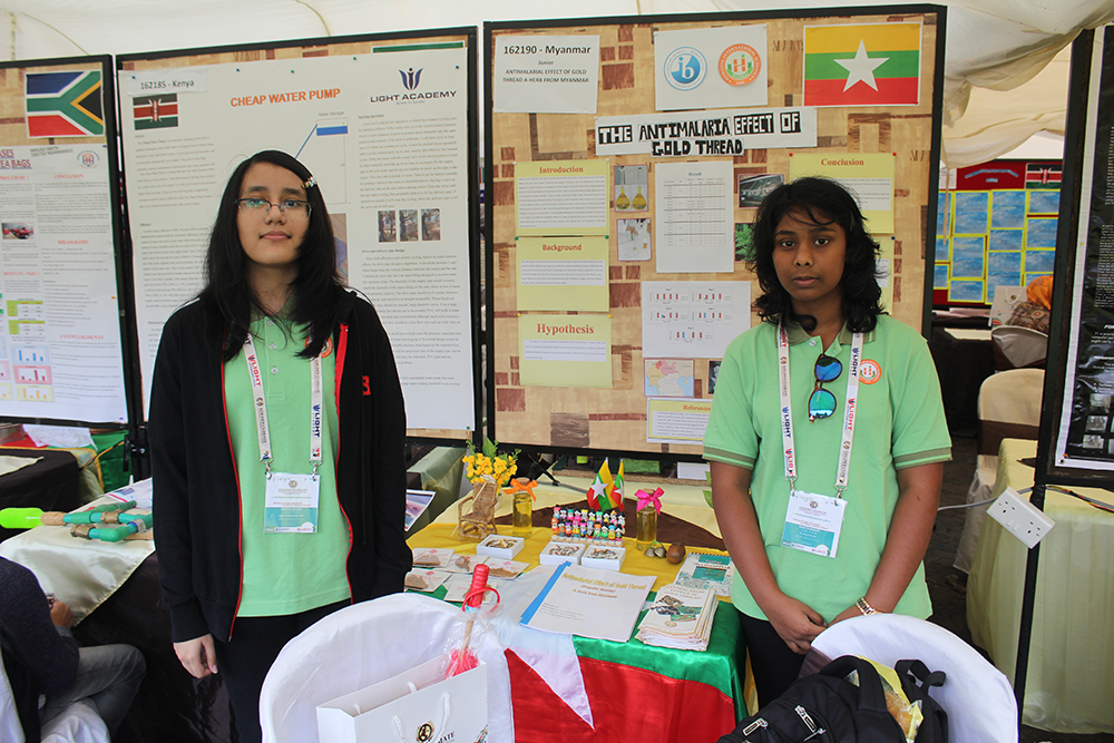 Two students standing at their project stand in front of their research posters
